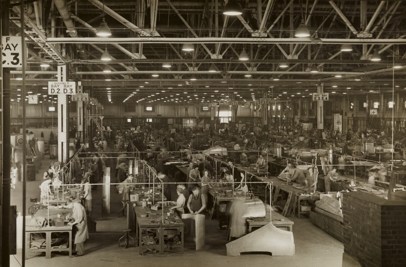 Black and white photo of manufacturing assembly lines circa 1940s.