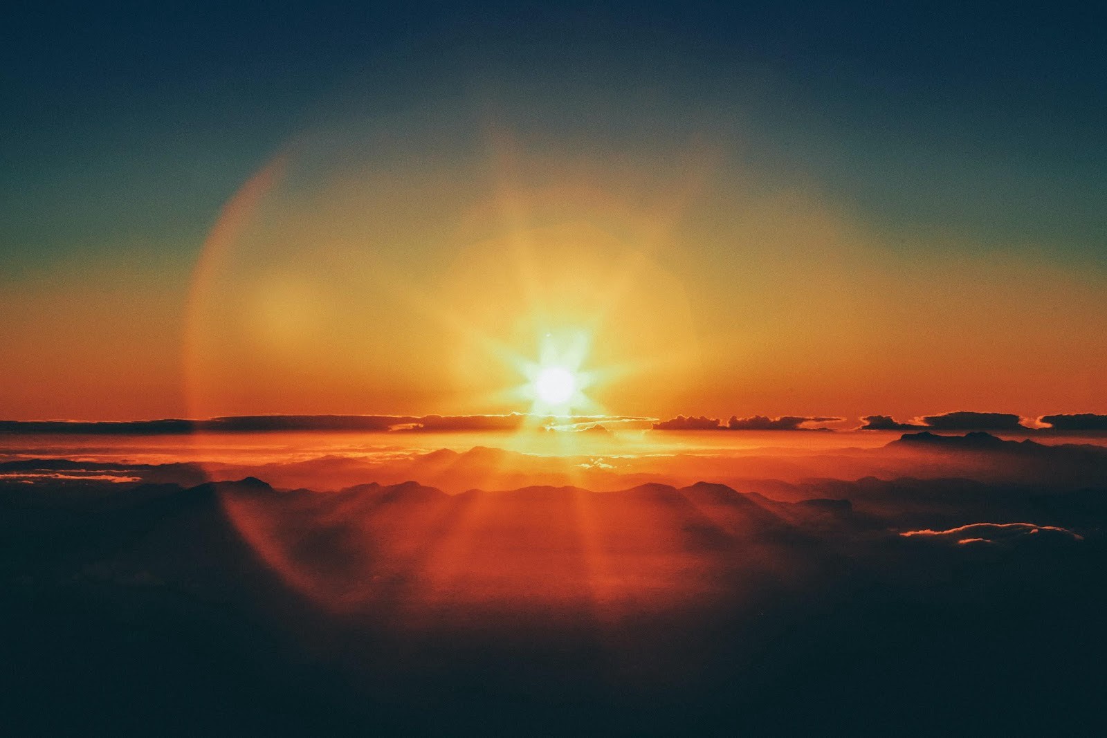 Sun setting over clouds.